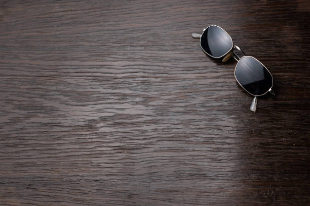 istock Sunglasses on a dark wooden table. 1146921097