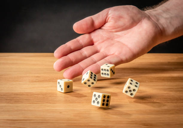istock Hand throwing dice in front of a dark background. 1146921259