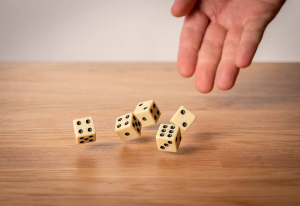 istock Hand throwing dice in front of a dark background. 1146921271