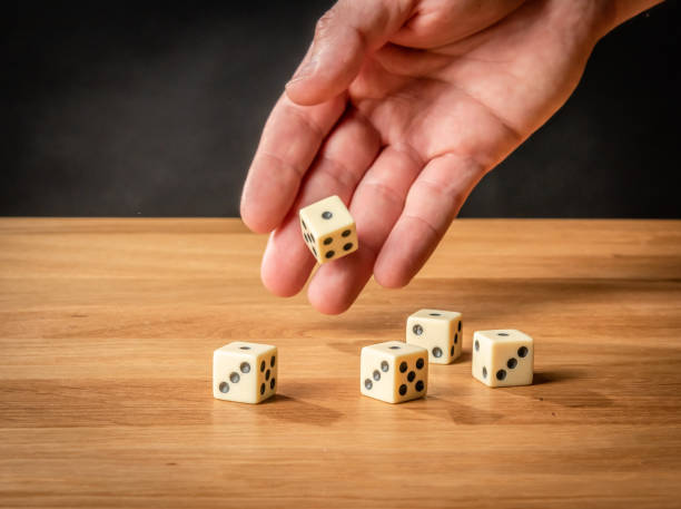 istock Hand throwing dice in front of a dark background. 1146921283
