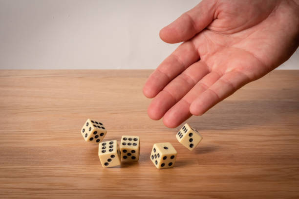 istock Hand throwing dice in front of a dark background. 1146921289