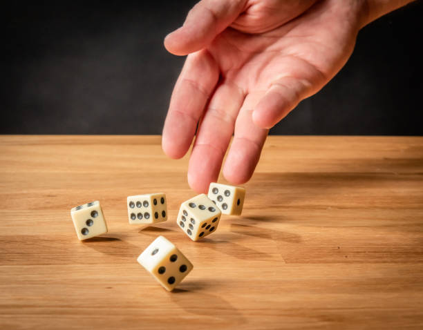 istock Hand throwing dice in front of a dark background. 1146921307