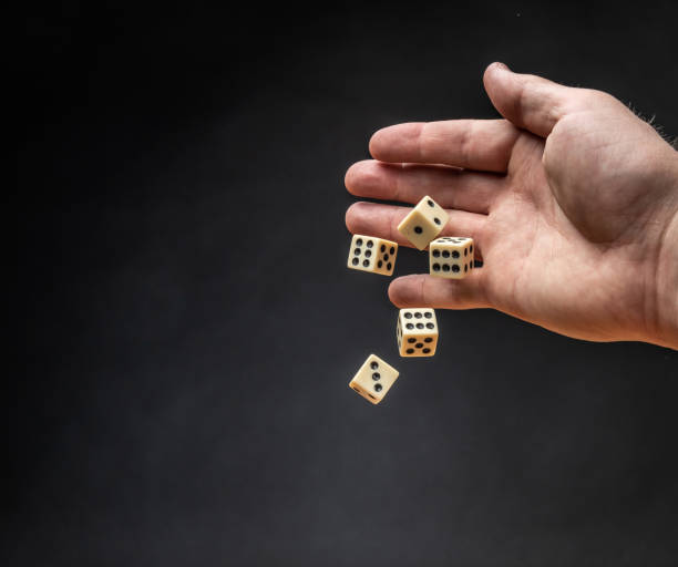 istock Hand throwing dice in front of a dark background. 1146921340