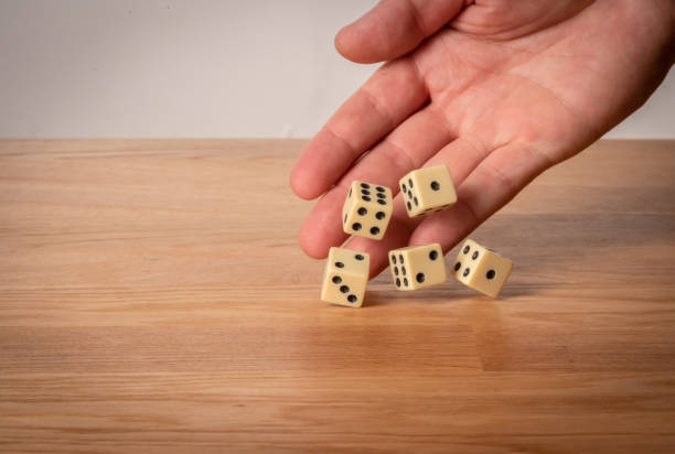 istock Hand throwing dice in front of a dark background. 1146921349
