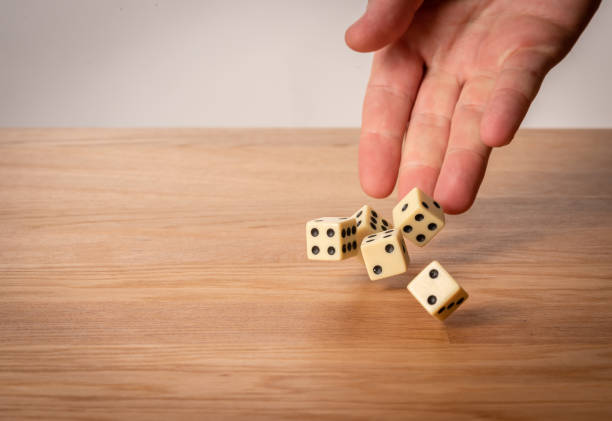 istock Hand throwing dice in front of a dark background. 1146921350