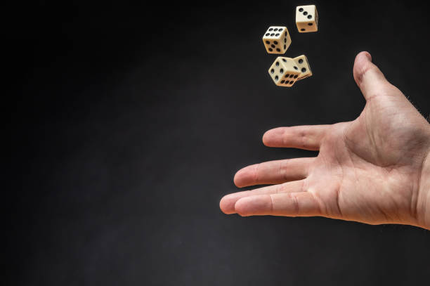 istock Hand throwing dice in front of a dark background. 1146921367