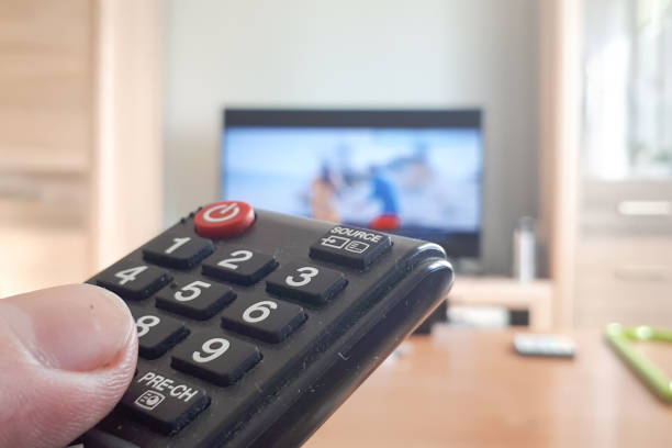 istock Hand Holding Use Remote Control and Watching TV in House with Warm and Relaxing atmosphere 1146921492
