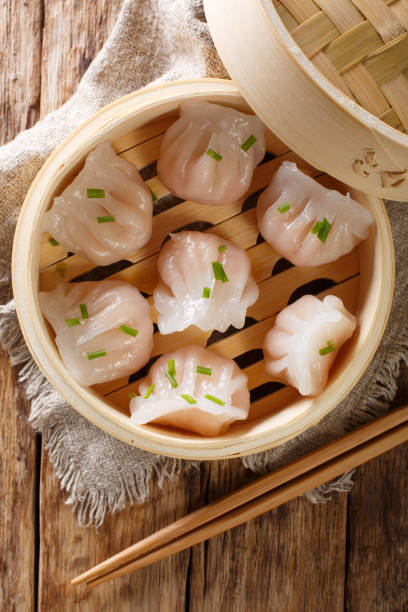 istock Chinese prawn dumplings dim sum placed in a bamboo steamer. Vertical top view 1146922756