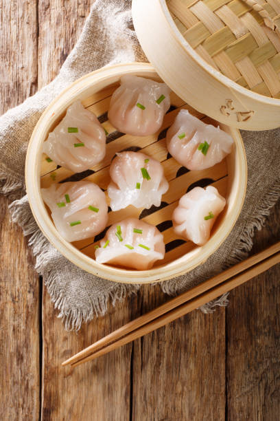 istock Dim Sum in bamboo steamer, Chinese cuisine. Closeup rustic. Vertical top view 1146922914