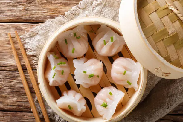 Dim Sum in bamboo steamer, Chinese cuisine. Closeup rustic style. horizontal top view from above