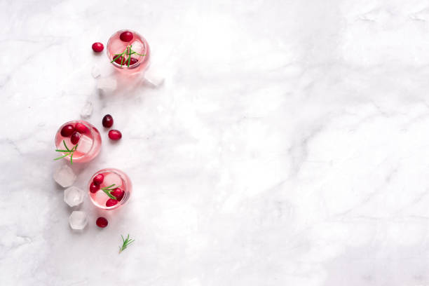 Cranberry Vodka Cocktail Cranberry Vodka Cocktail with ice cubes and rosemary on white marble background, copy space. Homemade alcohol cocktail with cranberries. vodka soda top view stock pictures, royalty-free photos & images