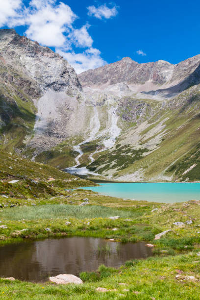 Lake Rifflsee in the Pitztal in Austria with deep blue sky and a little pond in the foreground