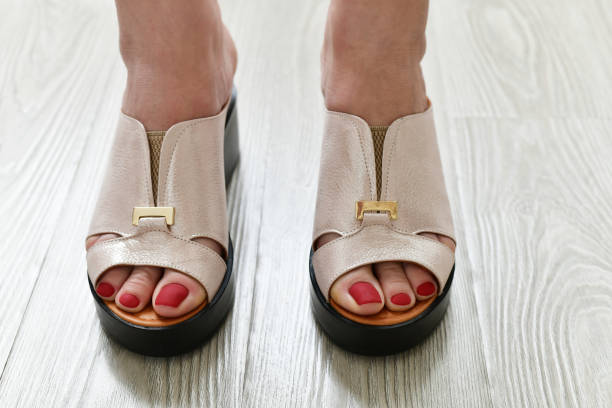 istock The Womens legs in summer white clogs 1146947390