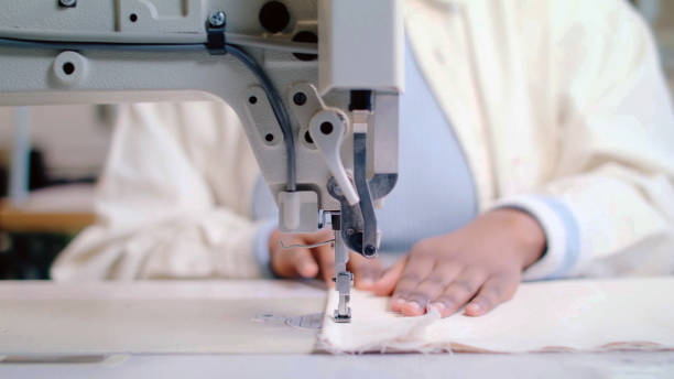 sewing machine with hands of dressmaker - textile sewing women part of imagens e fotografias de stock