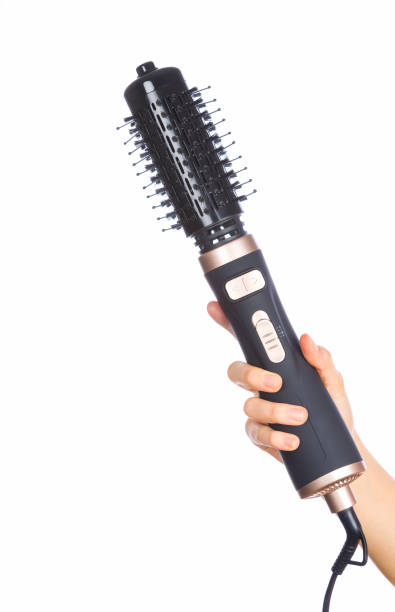 istock Hand holding hair curling iron round brush 1146950559