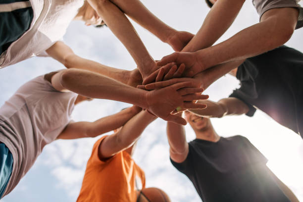 istock Cheerful group of teammates holding hands as a team 1146952112
