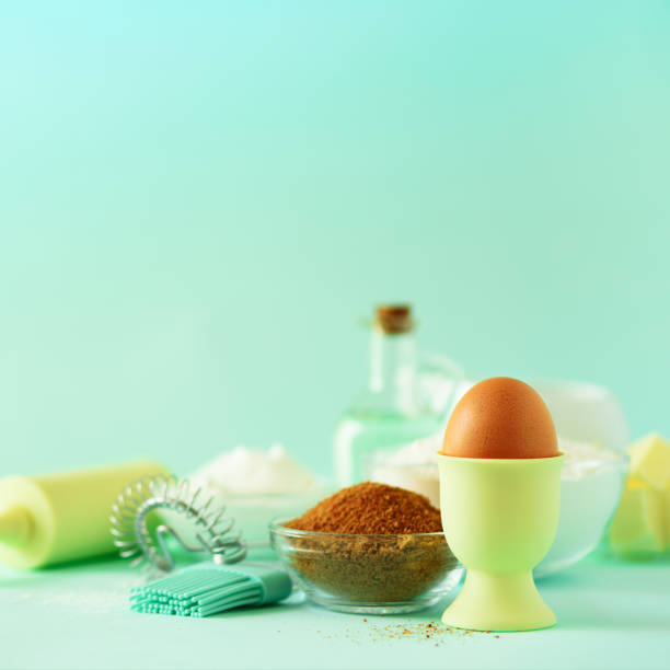 istock Bakery food frame, cooking concept. Different baking ingredients - butter, sugar, flour, milk, eggs, oil, spoon, rolling pin, brush, whisk over blue background. Copy space. Square crop 1146957596