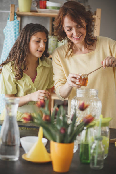 istock Woman sweetening lemonade with honey 1146957853
