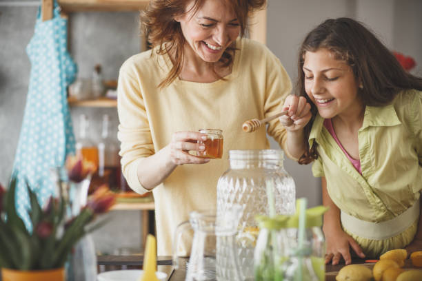 istock Woman sweetening lemonade with honey 1146957854