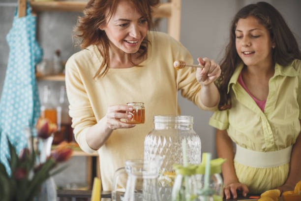 istock Woman sweetening lemonade with honey 1146957856