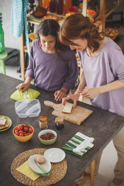 istock Mother and daughter preparing healthy lunch at the kitchen table 1146959049