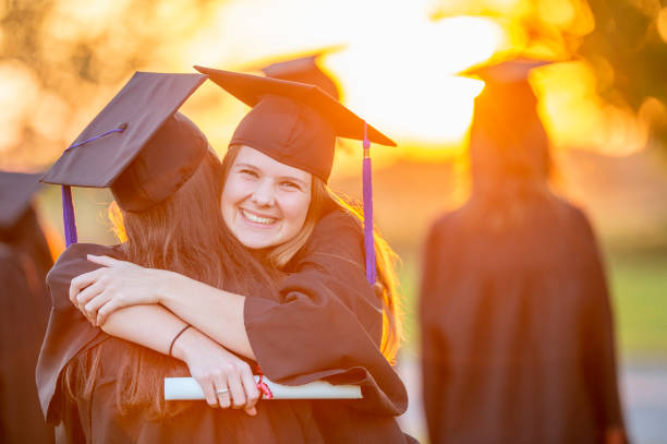 istock Two women hug at a graduation ceremony 1146959840