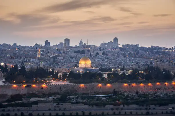 Jerusalem Old Town Cityscape of Temple Mount at Sunset. View of the Holy Land with the iconic Al-Aqsa Mosque - Golden Dome of the Rock- and Bell Tower of Church of the Redeemer,  Church of the Holy Sepulchre and Old Town City Wall. Jerusalem Old Town, Israel, Middle East.