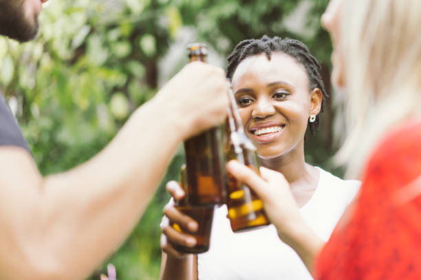 istock friends talking and toasting beers outdoors. Party people drinks toast celebration. 1146962294