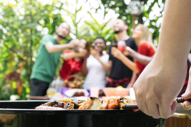 hand of bbq grilling and friends having barbecue party, outdoors - tailgate imagens e fotografias de stock