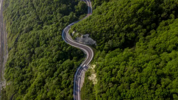 Photo of Top view of cars driving on zig zag winding mountain road