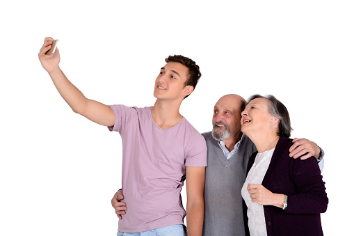 Grandparents and their teen grandson taking a selfie. Isolated on white background