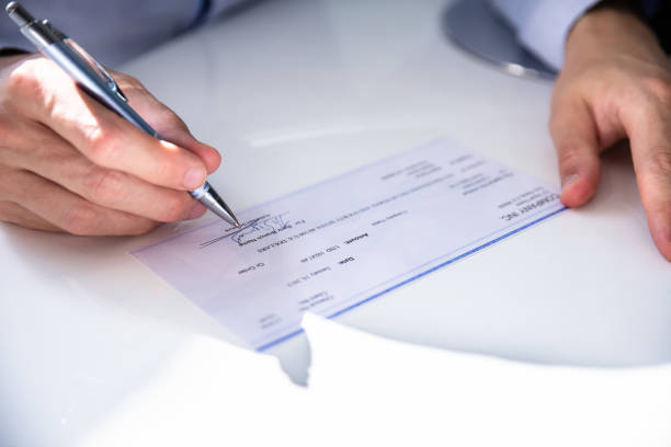 istock Close-up Of Hand Filling Cheque 1146964151