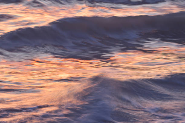 istock Colorful Sunlight on Ocean Waves At Sunrise Blurred Close Up Abstract 1146964324
