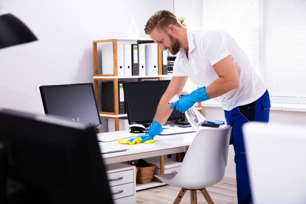 istock Janitor cleaning white desk in office 1146965012