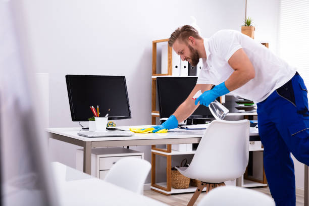 istock Janitor cleaning white desk in office 1146965015