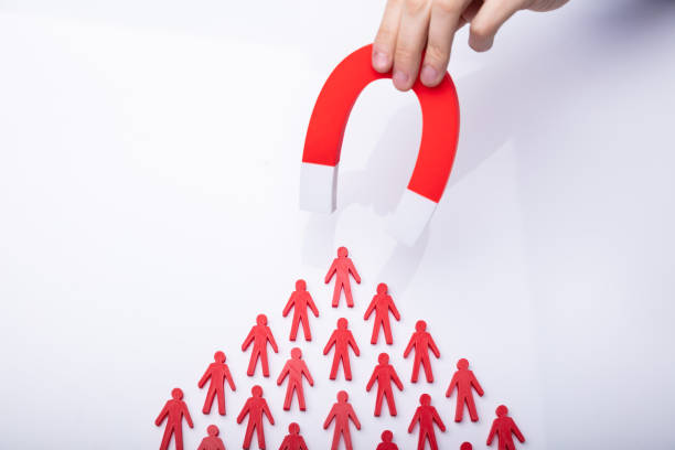 istock Businessman Attracting Red Team With Horseshoe Magnet 1146965400