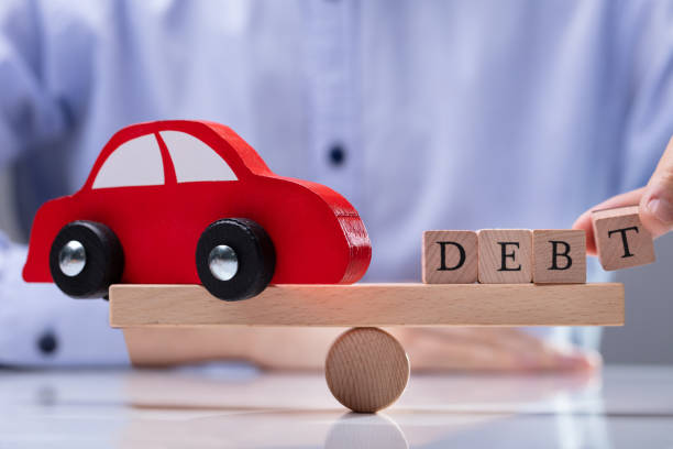 istock Red Car And Debt Word Balancing On Seesaw 1146965421