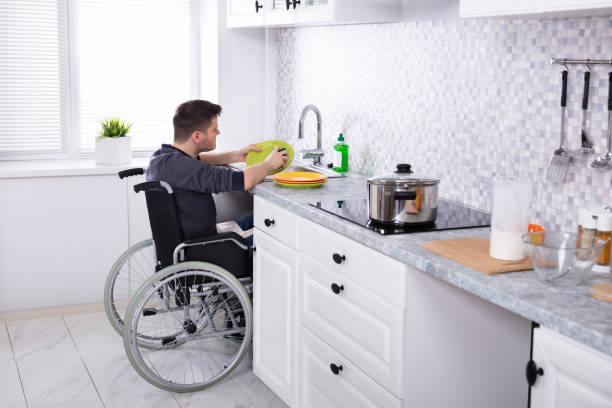 handicappato uomo pulizia piatti in cucina - indipendenza foto e immagini stock