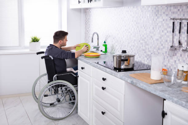 handicapped man cleaning dishes in kitchen - independence imagens e fotografias de stock