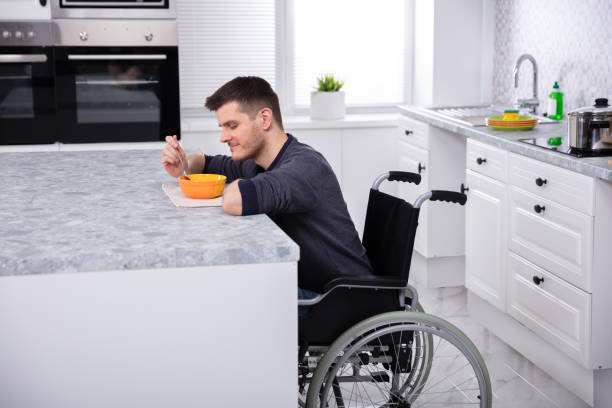 istock Smiling Handicapped Man Drinking Soup In The Kitchen 1146966647
