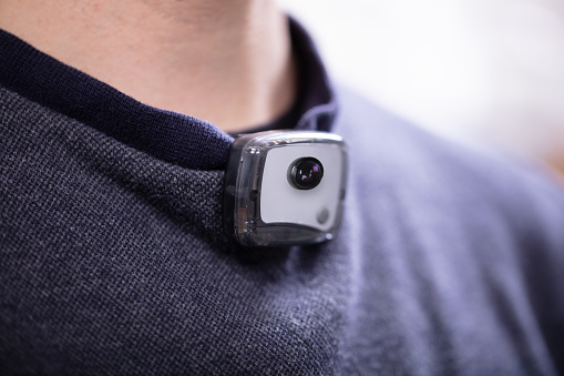 Close-up Of Surveillance Camera On Man's T-shirt Near His Neck