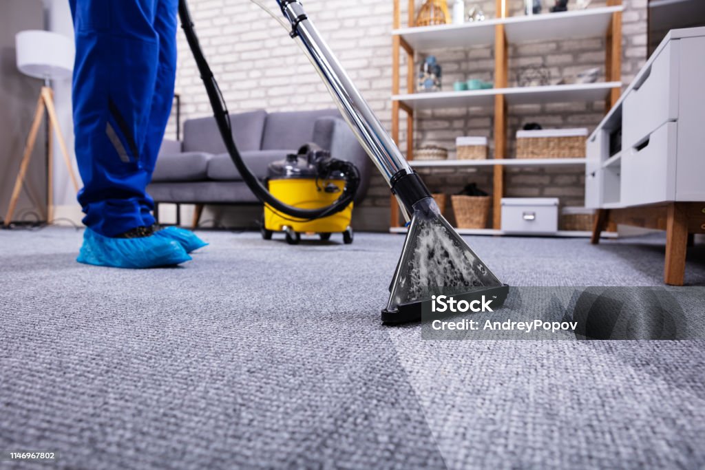 人清潔地毯與真空吸塵器 - 免版稅清洗圖庫照片