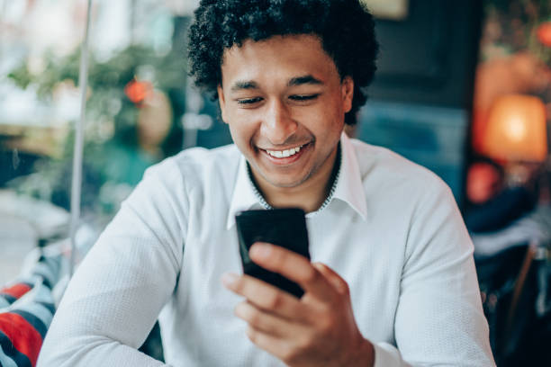 istock Happy afro-american man  using smart phone at cafe 1146968071