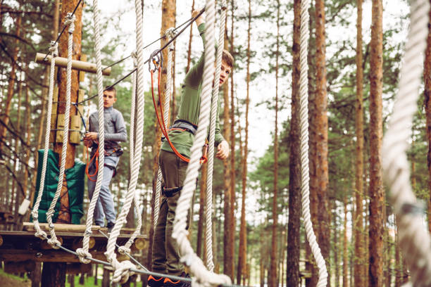 défi du parcours d’obstacles adventure park - high up obstacle course ropes course teenage boys photos et images de collection