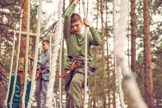 défi du parcours d’obstacles adventure park - high up obstacle course ropes course teenage boys photos et images de collection