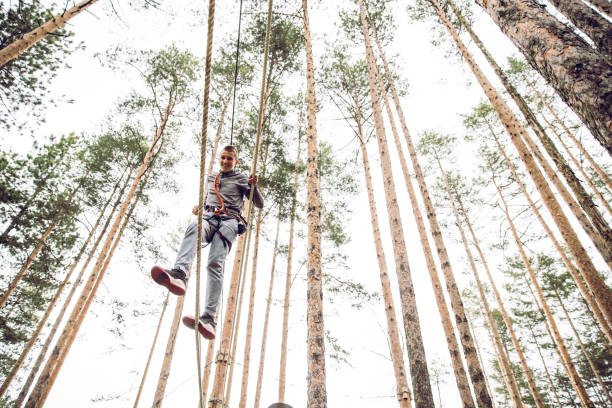 parcours d’obstacles dans un parc d’aventures - high up obstacle course ropes course teenage boys photos et images de collection