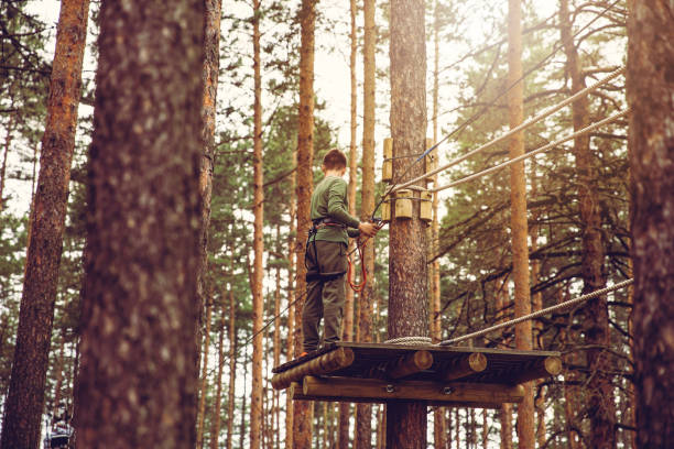 défi du parcours d’obstacles adventure park - high up obstacle course ropes course teenage boys photos et images de collection