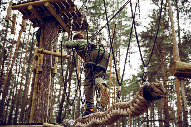 parcours d’obstacles dans un parc d’aventures - high up obstacle course ropes course teenage boys photos et images de collection