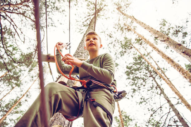 parcours d’obstacles dans un parc d’aventures - high up obstacle course ropes course teenage boys photos et images de collection