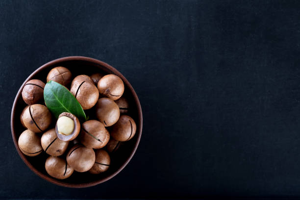 istock Macadamia nuts in clay plate on black background 1146969409